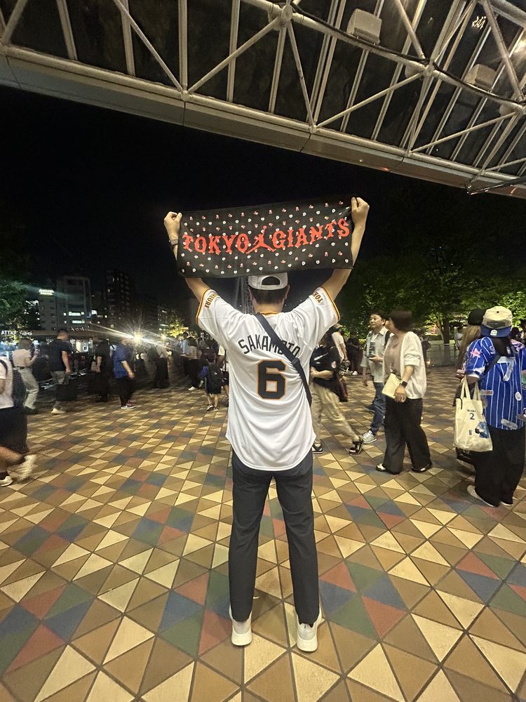 東京ドームの前でTOKYO GIANTSのタオルを掲げる後ろ姿